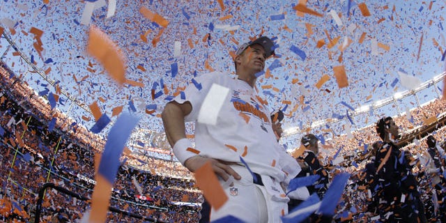 January 19, 2014: Denver Broncos quarterback Peyton Manning is engulfed in confetti during the trophy ceremony after the AFC Championship NFL playoff football game in Denver. The Broncos defeated the Patriots 26-16 to advance to the Super Bowl. (AP Photo/Charlie Riedel)