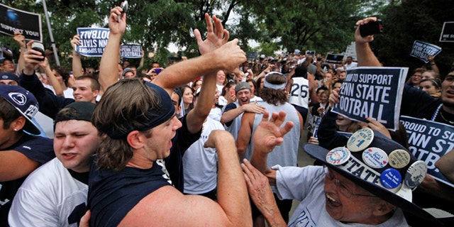 July 31, 2012: Penn State University linebacker Michael Mauti, second from left foreground, and his teammates are greeted by a pep rally of supporters on the way to a morning workout outside the Lasch Football building on the Penn State main campus in State College, Pa.