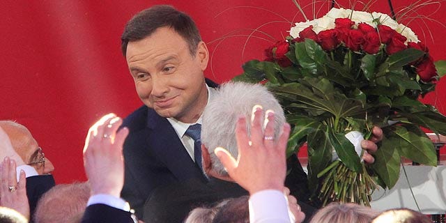 May 24, 2015: Opposition candidate Andrzej Duda celebrates with supporters as the first exit polls in the presidential runoff voting are announced in Warsaw. (AP Photo/Czarek Sokolowski)