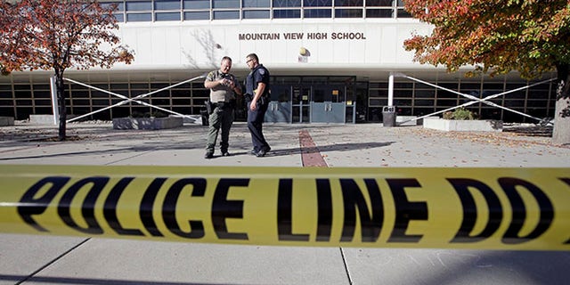 Police stand outside Mountain View High School after several students were stabbed inside the high school Tuesday, Nov. 15, 2016, in Orem, Utah Police say a 16-year-old boy was taken into custody after the stabbings. (AP Photo/Rick Bowmer)