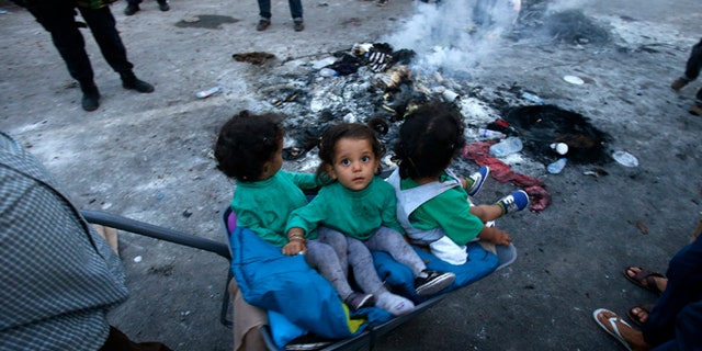 Sept. 16, 2015: A migrant pushes a wheelbarrow with children at the "Horgos 2" border crossing.