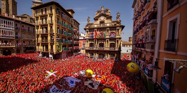 Revelers hold up traditional red neckties during the launch of the "Chupinazo" rocket, to celebrate the official opening of the 2015 San Fermin fiestas in Pamplona, Spain, Monday, July 6, 2015. Revelers from around the world turned out here to kick off the festival with a messy party in the Pamplona town square, one day before the first of eight days of the running of the bulls. (AP Photo/Andres Kudacki)