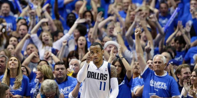 Fans cheer as Dallas Mavericks' Monta Ellis (11) celebrates after scoring and being fouled by the San Antonio Spurs in the second half of Game 6 of an NBA basketball first-round playoff series on Friday, May 2, 2014, in Dallas. The Mavericks won 113-111. (AP Photo/Tony Gutierrez)