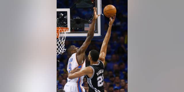 Oklahoma City Thunder forward Serge Ibaka (9) gets up to block a shot by San Antonio Spurs forward Tim Duncan (21) in the first quarter of Game 3 of an NBA basketball playoff series of the Western Conference finals, Sunday, May 25, 2014, in Oklahoma City. (AP Photo/Sue Ogrocki)