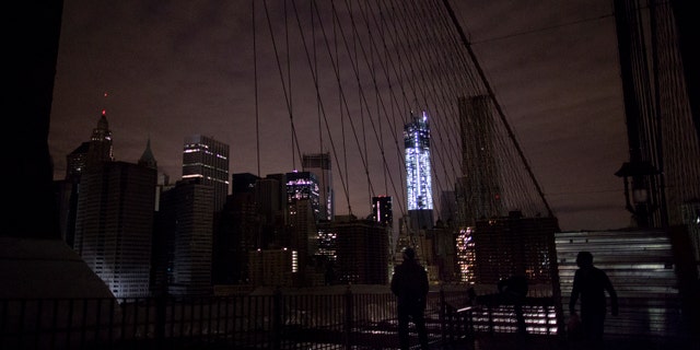 Much of lower Manhattan remains dark, as viewed from the darkened Manhattan side of the pedestrian walkway of the Brooklyn Bridge, Thursday, Nov. 1, 2012 in New York. In the wake of superstorm Sandy, power outages still plague much of the New York area. (AP Photo/Craig Ruttle)