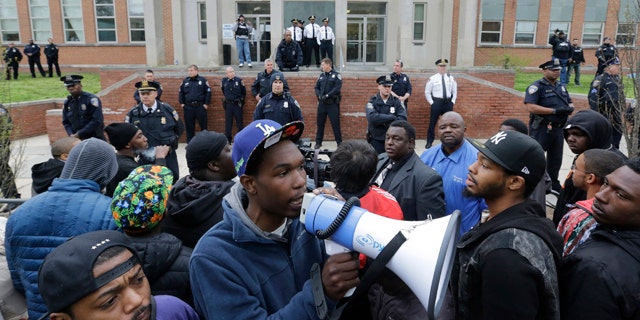 April 23, 2015: Protesters for Freddie Gray stand outside the Baltimore Police Department's Western District police station. Gray died from spinal injuries about a week after he was arrested and transported in a police van. (AP Photo/Patrick Semansky)