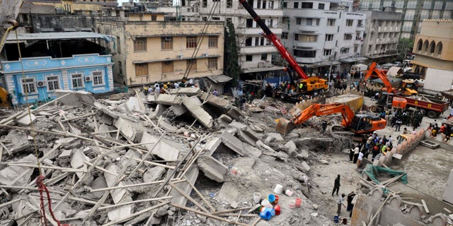 March 29, 2013 - Rescuers using mechanical diggers remove rubble from the site of a collapsed building in downtown Dar es Salaam, Tanzania.