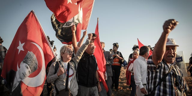 Aug. 5, 2013 - People hold national flags as they shout slogans outside the Silivri jail complex in Silivri, Turkey. Some 250 people - including military officers, politicians and journalists - received verdicts in a landmark and divisive trial in Turkey over an alleged conspiracy to overthrow Prime Minister Recep Tayyip Erdogan's government. Security forces set up barricades around the courthouse in Silivri to tighten security after supporters of defendants announced a demonstration against the five-year trial.