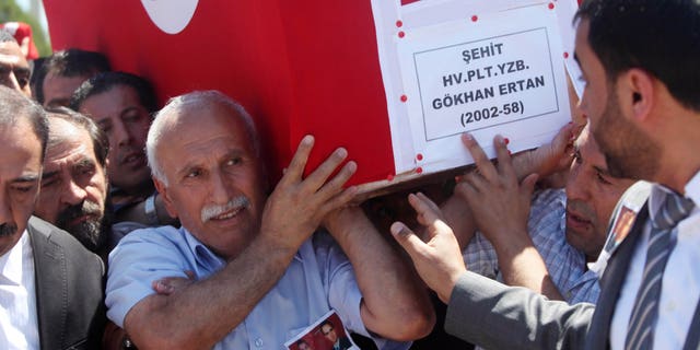 Ali Ertan, center, carries the coffin of his son, Captain Gokhan Ertan, after a religious funeral at a mosque in the eastern Turkish city of Malatya, Turkey, Friday, July 6, 2012. Turkey's Prime Minister Recep Tayyip Erdogan and top military commanders has joined hundreds of mourners at the funeral of two pilots whose jet was shot down by Syria two weeks ago. The somber ceremony took place at an air base in Malatya, from where the pilots' plane had originally taken off.(AP Photo)