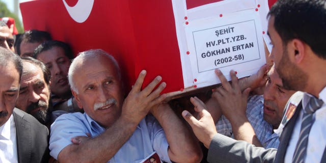 Ali Ertan, center, carries the coffin of his son, Captain Gokhan Ertan, after a religious funeral at a mosque in the eastern Turkish city of Malatya, Turkey, Friday, July 6, 2012. Turkey's Prime Minister Recep Tayyip Erdogan and top military commanders has joined hundreds of mourners at the funeral of two pilots whose jet was shot down by Syria two weeks ago. The somber ceremony took place at an air base in Malatya, from where the pilots' plane had originally taken off.(AP Photo)