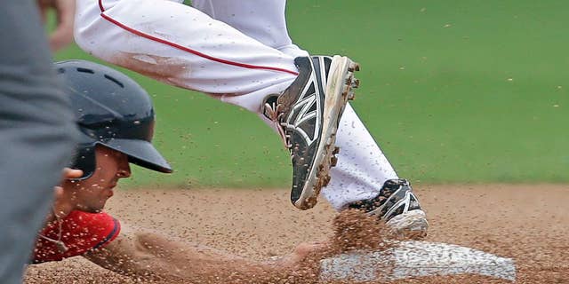 Minnesota Twins' Levi Michael is caught out trying to return to second base as Boston Red Sox second baseman Heiker Meneses covers on a double play off the bat of the Twins' Josh Willingham during the sixth inning of an exhibition baseball game in Fort Myers, Fla., Saturday, March 29, 2014. (AP Photo/Gerald Herbert)