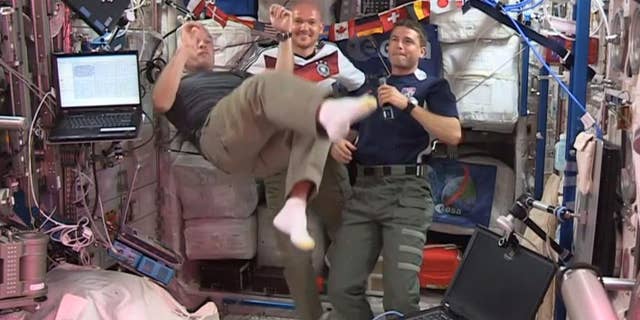 In this undated frame grab from video provided by NASA, United States astronauts Steve Swanson, left, Reid Wiseman, right, and German astronaut Alexander Gerst, center, kick around a soccer ball some 230 miles above Earth aboard the International Space Station. The astronauts say they will be watching the World Cup games. (AP Photo/NASA)