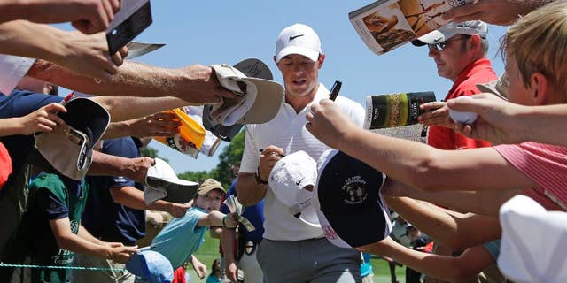 Rory McIlroy signs autographs as he walks to the third tee during the pro-am for the Wells Fargo Championship golf tournament at the Quail Hollow Club in Charlotte, N.C., Wednesday, May 13, 2015. (AP Photo/Chuck Burton)
