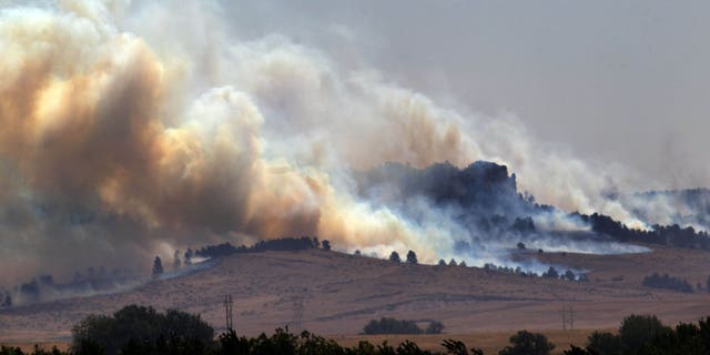 In this Saturday, Sept. 1, 2012 photo, smoke plumes rise from the West Ash Creek wildfire near Crawford Neb. The blaze is one of three wildfires burning in Nebraska and South Dakota, started earlier in the week by lightning. (AP Photo/Omaha World-Herald, Mark Davis) MAGS OUT; ALL NEBRASKA LOCAL BROADCAST TV OUT