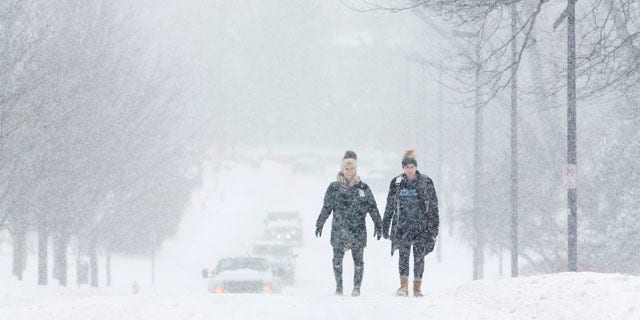 Feb. 16, 2015: University of Kentucky students Courtney Wiseman, left, and Abby Lerner walk home after studying on campus even as classes were canceled for the day in Lexington. (AP Photo/David Stephenson)