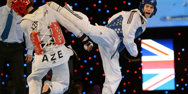 May 5, 2012: Great Britain's Aaron Cook, right, aims a kick on his way to controversially beating Ramin Azizov of Azerbaijan in the final of the Men's 80kg competition during the European Taekwondo Championships, at the Manchester Regional Arena, Manchester, England.