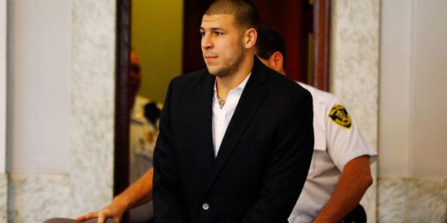 NORTH ATTLEBORO, MA - AUGUST 22: Aaron Hernandez is escorted into the courtroom of the Attleboro District Court for his hearing on August 22, 2013 in North Attleboro, Massachusetts. Former New England Patriot Aaron Hernandez has been indicted on a first-degree murder charge for the death of Odin Lloyd. (Photo by Jared Wickerham/Getty Images)