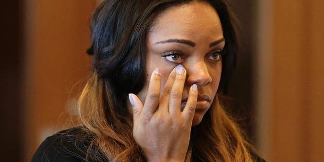 FILE - In this Oct. 15, 2013, file photo, Shayanna Jenkins, girlfriend of former New England Patriots' Aaron Hernandez, wipes her eye in superior court, in Fall River, Mass., during her arraignment on a perjury charge in connection with the killing of Hernandez's friend. In new filings in Fall River Superior Court, Jenkins’ attorney asks a judge to order Massachusetts prosecutors to turn over any messages that are “consistent with her being asked to remove items” from their North Attleborough home. The filing by attorney Janice Bassil refers to another text message that prosecutors allege instructed Jenkins, in code, to damage a video surveillance system. (AP Photo/Steven Senne, Pool, File)