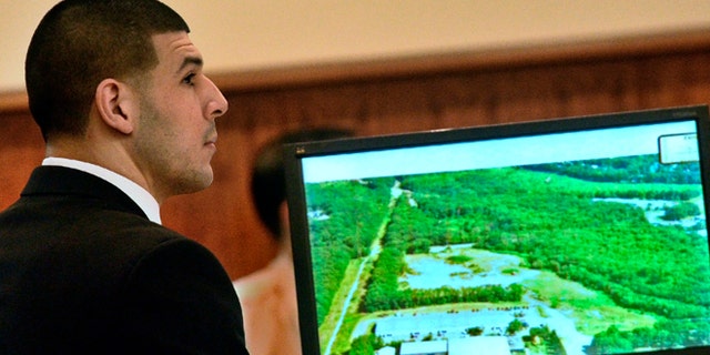 Former New England Patriots football player Aaron Hernandez listens during his murder trial as a prosecution exhibit is displayed, Friday, Jan. 30, 2015, in Fall River, Mass. Hernandez is charged with killing semiprofessional football player Odin Lloyd, 27, in June 2013. (AP Photo/The Boston Herald, Ted Fitzgerald, Pool)