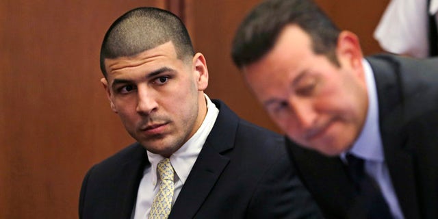 FILE - In this Thursday, July 21, 2016 file photo, Former New England Patriots wide receiver Aaron Hernandez, left, looks down the table at his legal team as his new defense attorney Jose Baez, right, takes a seat during a court appearance at Plymouth Superior Court in Plymouth, Mass. Hernandez is due in Suffolk Superior Court on Tuesday, Aug. 16, for a hearing in the 2012 killings of two men outside a Boston nightclub. Hernandez has pleaded not guilty. (AP Photo/Charles Krupa, Pool, File)