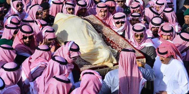 In this Friday, Jan. 23, 2015 photo, provided by the Saudi Press Agency, members of the Saudi royal family carry the body of King Abdullah, who died early Friday during his funeral in Riyadh, Saudi Arabia. In line with the strict interpretation of Islamic tradition observed in the kingdom, Abdullah was buried in an unadorned, beige cloth without a coffin in an unmarked grave. World leaders and top dignitaries began arriving in Saudi Arabia on Saturday, Jan. 24, 2015 to give their condolences following the death of King Abdullah at age 90 after nearly two decades at the helm. (AP Photo/SPA)