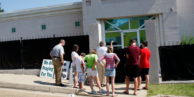 June 27, 2012: In this photograph, anti-abortion advocates stand outside Mississippi's only abortion clinic, singing and praying for their patients, and "counseling" them to reject abortion.