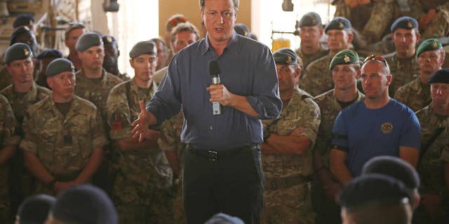 Britain's Prime Minister David Cameron, centre, addresses British troops, in Camp Bastion, Afghanistan, Friday, Oct. 3, 2014. Cameron on Friday pledged support for Afghanistan's newly sworn-in president and the country's new unity government, saying during a surprise visit to Kabul that Britain is committed to helping Afghans build a more secure and prosperous future. (AP Photo/Dan Kitwood, Pool)