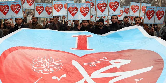 Afghans hold posters that read, "I love Muhammad," during a protest against caricatures published in French magazine Charlie Hebdo outside the French Embassy, in Kabul, Afghanistan, Thursday, Jan. 22, 2015. Around 100 people have demonstrated in the Afghan capital against the publishers of the French satirical magazine Charlie Hebdo, accusing them of blasphemy. (AP Photo/Rahmat Gul)
