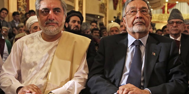 May 11, 2014: Afghan presidential candidate Abdullah Abdullah, left, and Afghan presidential candidate Zalmai Rassoul, right, listen during a news conference in Kabul, Afghanistan. (AP Photo/Massoud Hossaini)