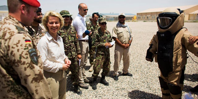 July 23, 2014: German Defence Minister Ursula von der Leyen, second left, stands next to an Afghan soldier wearing a bomb suit, right, during a demonstration at a sapper training facility at Camp Shaheen outside Mazar-i-Sharif, Afghanistan. (AP)