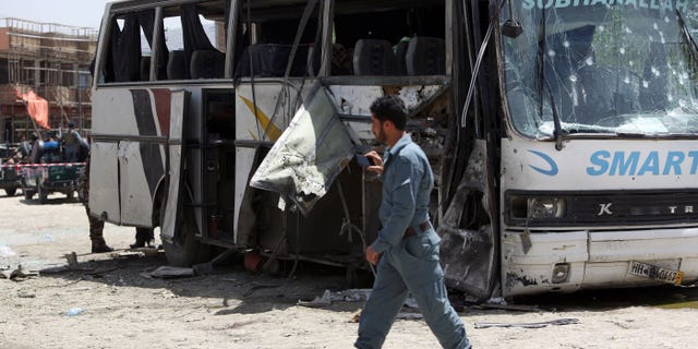 May 4, 2015 - An Afghan security man inspects the site of a suicide attack in Kabul, Afghanistan. An Afghan official says a suicide bomber struck a minibus carrying government employees in Kabul, killing at least one person and wounding more than a dozen.
