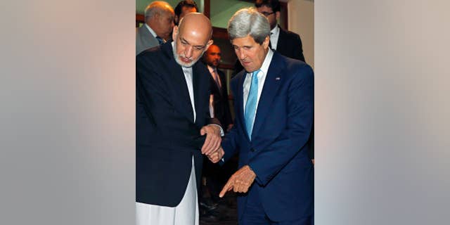 U.S. Secretary of State John Kerry, right, and Afghanistan's President Hamid Karzai talk as Karzai says goodbye to Kerry after a dinner at the presidential palace in Kabul, Afghanistan, Friday, July 11, 2014. Kerry visited Afghanistan in hopes of diffusing a crisis over the runoff presidential election to find a successor for outgoing President Karzai. (AP Photo/Jim Bourg, Pool)