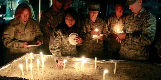 U.S. soldiers place lit candles as they gather to mark Memorial Day at the U.S. Army Corps of Engineers' headquarters in Kabul, Afghanistan on Sunday, May 29, 2011. Some U.S. troops in Afghanistan have held a candlelit remembrance for those lost ahead of Memorial Day.