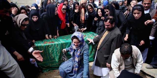 March 22, 2015: Civil society activists and relatives gather around the coffin of 27-year-old Farkhunda, an Afghan woman who was beaten to death by a mob, during her funeral.