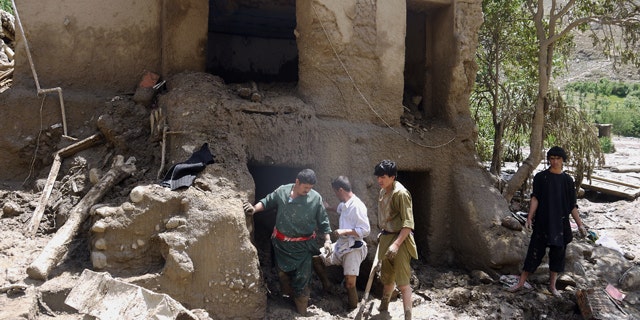 June 7, 2014: Afghans look for their belongings in their house damaged after flooding in the northeastern Baghlan province, north of Kabul. (AP Photo/Javid Basharat)