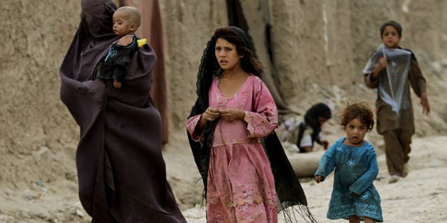July 30, 2013: Displaced Afghans walks near their temporary homes on the outskirts of Kabul, Afghanistan. (AP Photo/Ahmad Jamshid)