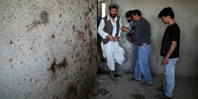 July 17, 2014: An Afghan man, left, enters a room which Taliban fighters used during a clash with Afghanistan's forces in Kabul. Gunmen launched a pre-dawn attack on the Kabul International Airport in the Afghan capital on Thursday, raining down rockets on the sprawling facility, setting off a gun battle with security forces and forcing the airport to close, officials said. (AP Photo/Massoud Hossaini)
