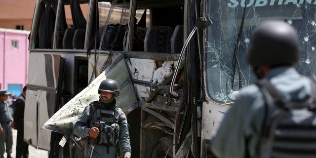 May 4, 2015: Afghan security forces inspect the site of a suicide attack in Kabul. An Afghan official says a suicide bomber struck a minibus carrying government employees in Kabul, killing at least one person and wounding more than a dozen. (AP Photo/Rahmat Gul)