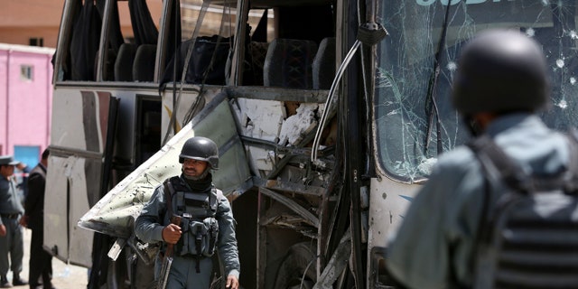 May 4, 2015: Afghan security forces inspect the site of a suicide attack in Kabul. An Afghan official says a suicide bomber struck a minibus carrying government employees in Kabul, killing at least one person and wounding more than a dozen. (AP Photo/Rahmat Gul)