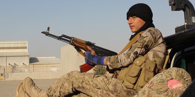 Sept. 30, 2015: An Afghan National Army soldier rests after he arrives in a camp, outside of Kunduz city, north of Kabul. (Najim Rahim via AP)