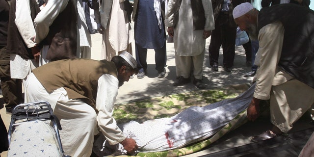 May 1, 2011: Relatives wrap the body of a civilian who was killed during a clash of militants with policemen in Ghazni southwest of Kabul, Afghanistan.