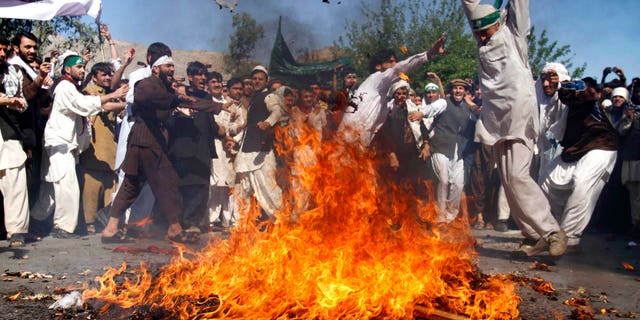 April 3: An Afghan protestor beats a burning effigy of U.S. President Barack Obama during a rally in Jalalabad, Afghanistan. Afghan protests against the burning of a Quran in Florida entered a third day with a demonstration in the major eastern city Sunday, while the Taliban called on people to rise up, blaming government forces for any violence. (AP)