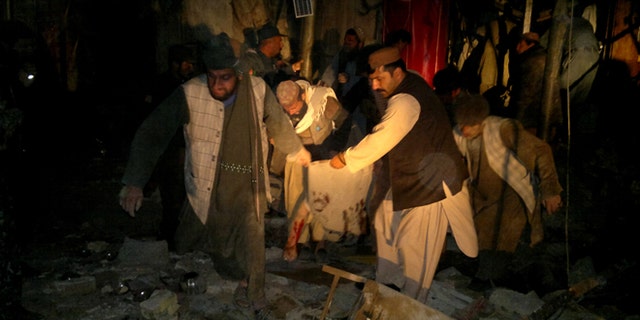 Feb. 25, 2014: Afghans carry the dead body of a civilian after a suicide attack in Trin Kot, capital of Uruzgan province, Afghanistan.