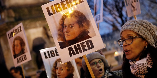 FILE - In this Jan. 4, 2018 file photo, demonstrators hold posters reading, "Release Ahed" during a protest demanding Israel to release Ahed Tamimi. Tamimi is to go on trial Tuesday, Feb. 13, 2018, before an Israeli military court, for slapping and punching two Israeli soldiers in December. Palestinians say her actions embody their David vs. Goliath struggle against a brutal military occupation, while Israel portrays them as a staged provocation meant to embarrass its military. Tamimi is one of an estimated 350 Palestinian minors in Israeli jails. (AP Photo/Christophe Ena, File)