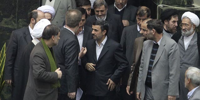 Feb. 1, 2012: In this photo released by the official website of the Iranian President's office, Iranian President Mahmoud Ahmadinejad, center, arrives at the parliament to deliver the new year's budget, as he is surrounded by lawmakers, in Tehran, Iran.
