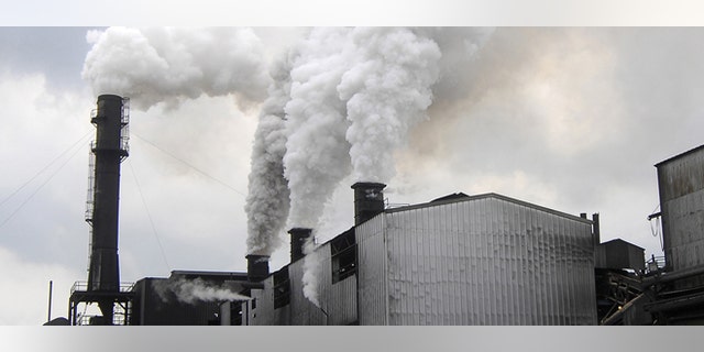 Smoke rises from the smoke stacks in the foreground from The Bryant Sugar House on Tuesday, April 10, 2007 in Pahokee, Fla. Faced with growing pressure from free trade, U.S. Sugar Corp., the nation's largest producer of cane sugar, is shuttering the plant, moving operations to another more high-tech mill about 30 miles away. (AP Photo/Steve Mitchell)