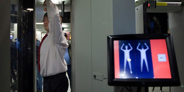An employee of Schiphol stands inside a body scanner during a demonstration at a press briefing at Schiphol airport, Netherlands. The Netherlands announced Wednesday, Dec. 30, it will immediately begin using full body scanners for flights heading to the United States, issuing a report that called the failed Christmas Day airline bombing a "professional" terror attack.