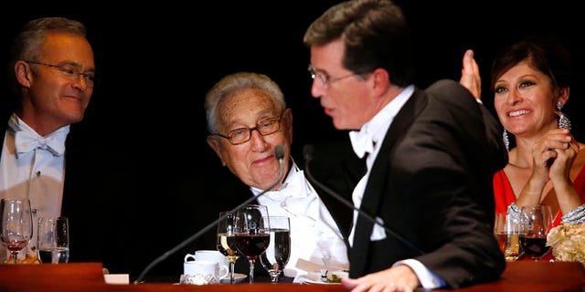 Oct. 17, 2013: Keynote speaker Stephen Colbert pokes fun at former U.S. Secretary of State Henry Kissinger, center, and CNBC anchor Maria Bartiromo, right, as CBS Evening News anchor Scott Pelley, left, looks on during the Alfred E. Smith Memorial Foundation Dinner, a charity gala organized by the Archdiocese of New York, at the Waldorf-Astoria hotel, in New York.