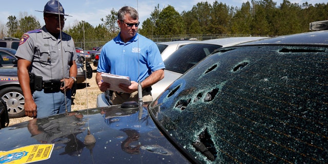 March 19: Mississippi Highway Patrol Lt. Col. Mike Holmes, right, and Cpl. Odis Easterling, survey the damage made by hail stones to a crusier in Pearl, Miss.