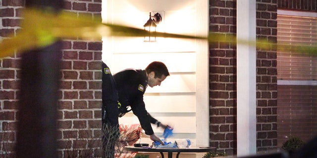 Jan. 9, 2013: A Noblesville policeman sets out crime scene gloves on a patio table, the scene of a stabbing in Noblesville, Ind.